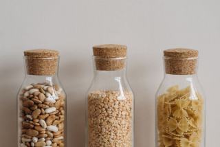 Bocaux de céréales et de légumineuses rangés dans un placard de cuisine