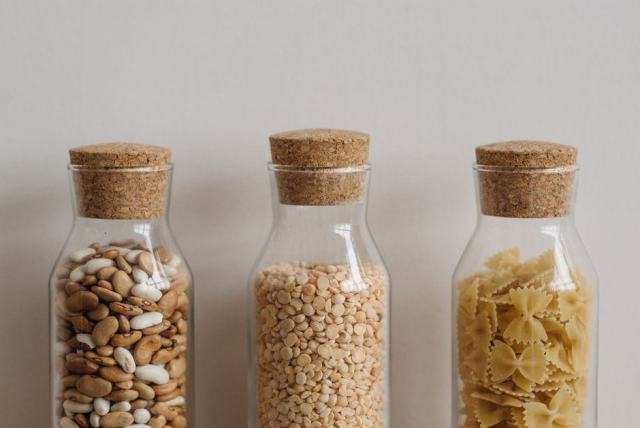 Bocaux de céréales et de légumineuses rangés dans un placard de cuisine